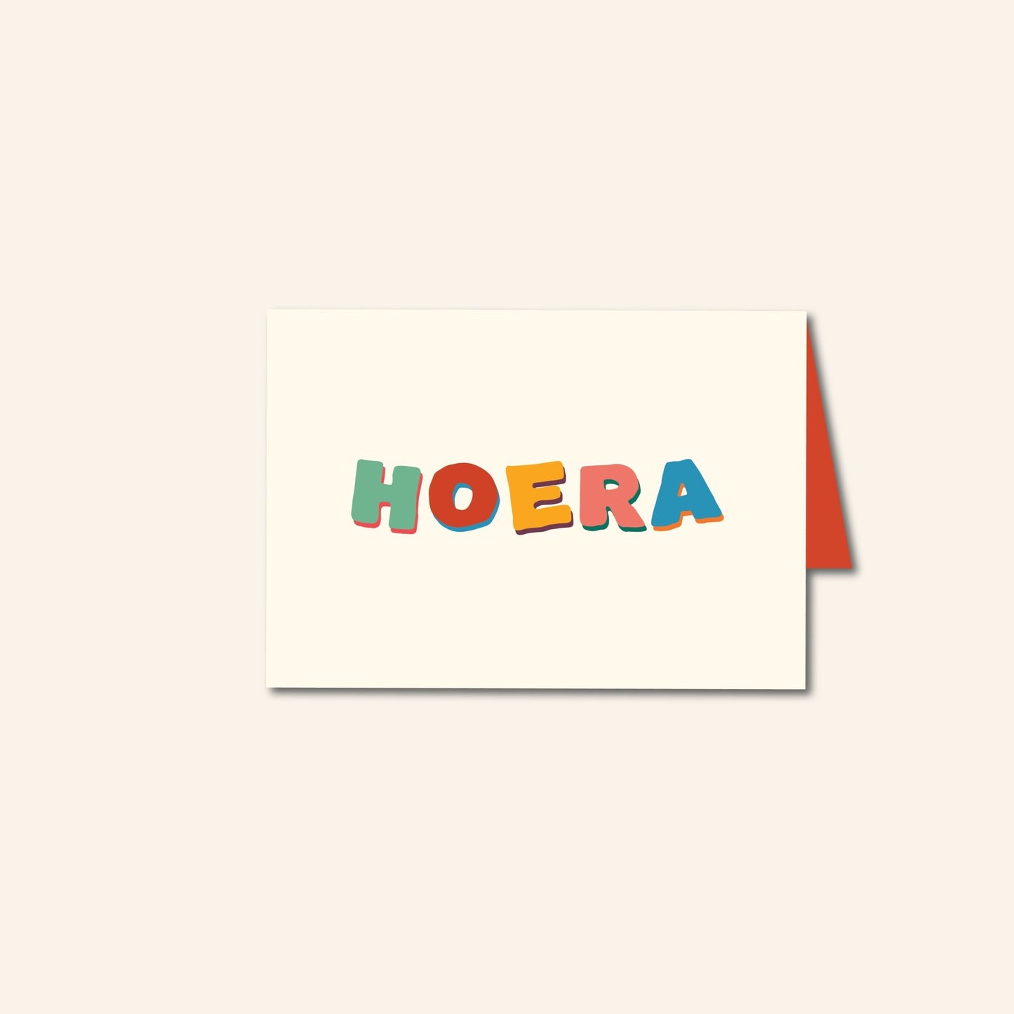 Wenskaart met kleurrijke handgetekende letters “Hoera” op een crèmekleurige achtergrond – feestelijk ontwerp van Studio Bloos.