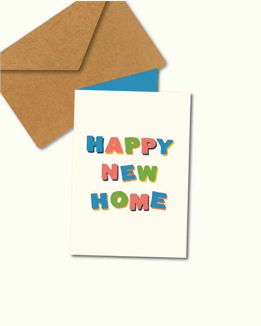 Wenskaart met de tekst “HAPPY NEW HOME” in kleurrijke, speelse letters op een crèmekleurige achtergrond, met een kraft envelop en een blauwe binnenkaart – illustratief ontwerp van Studio Bloos.