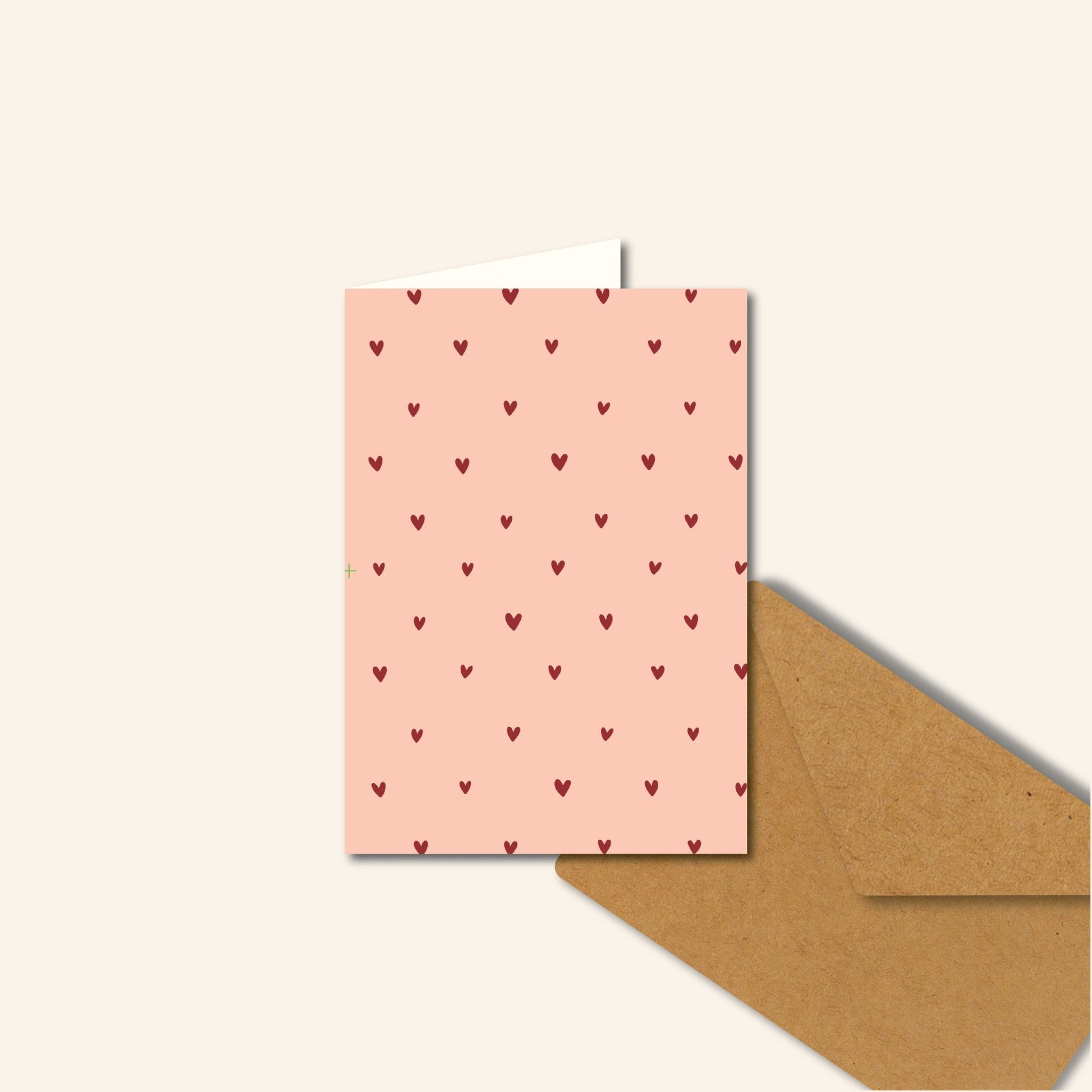 "Roze A6-wenskaart met hartjesmotief, blanco binnenkant" "Liefdevolle roze wenskaart met hartjes, geschikt voor elke gelegenheid" "Romantische A6-kaart in het roze met hartjes design" "Roze kaart met hartjes voor Valentijn, verjaardag of zomaar" "Wenskaart A6, roze met hartjes, op rood oppervlak" 