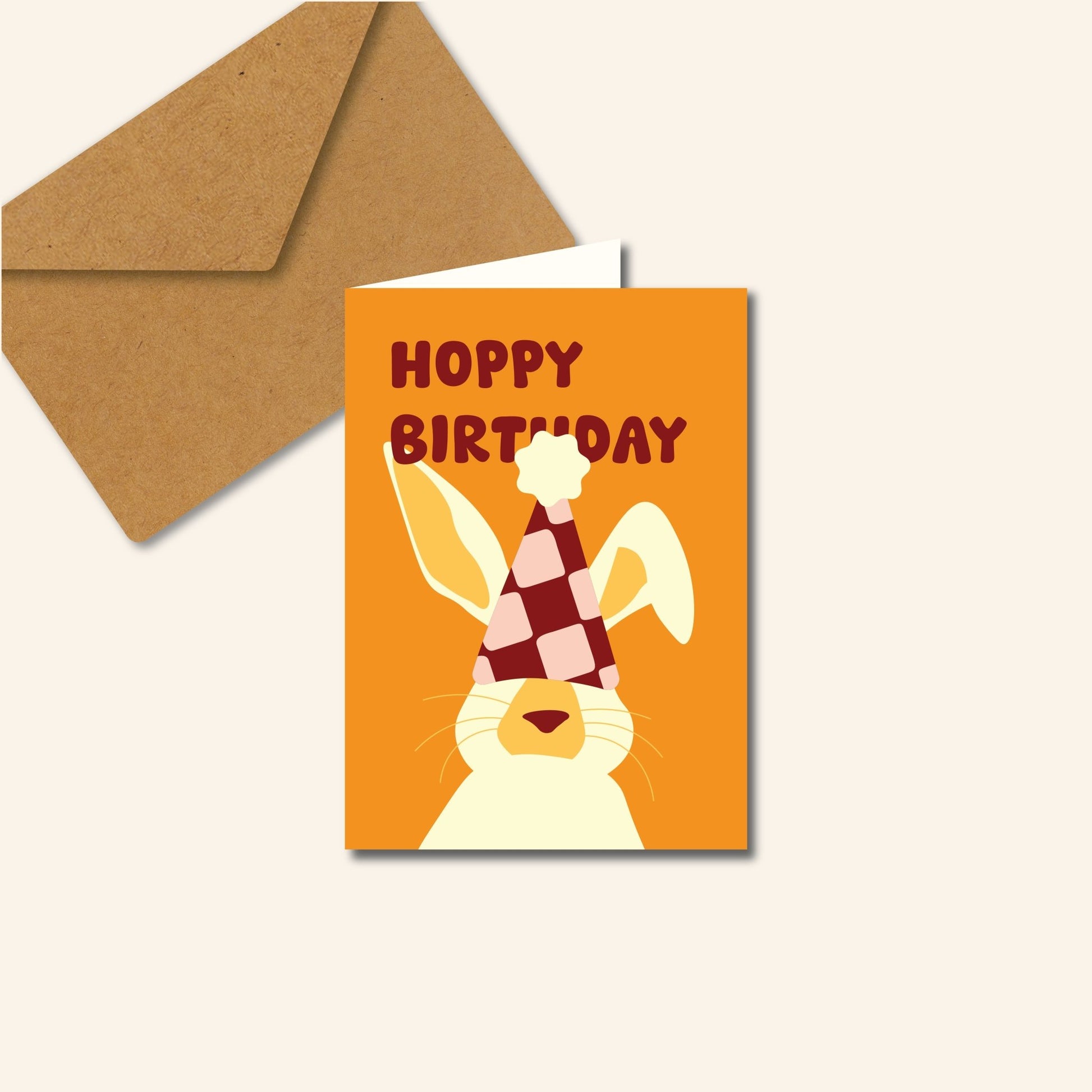 Wenskaart Hoppy Birthday met een illustratie van een konijn met feestmuts en vrolijke tekst, originele verjaardagskaart van Studio Bloos.