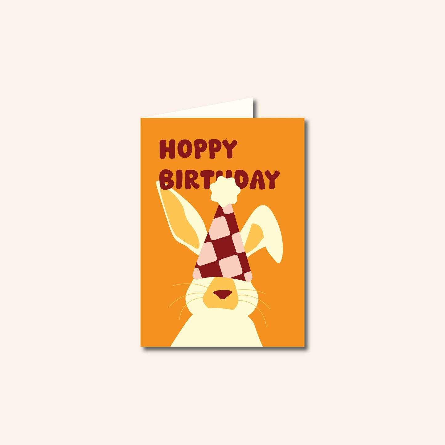 Wenskaart Hoppy Birthday met een illustratie van een konijn met feestmuts en vrolijke tekst, originele verjaardagskaart van Studio Bloos.